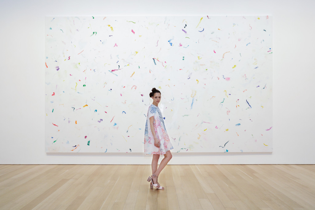 Paridust in front of a confetti painting by Dan Colen, at The Brant Foundation, Greenwich, Connecticut, wearing Tanya Taylor.  Photograph by Tylor Hou, 2014