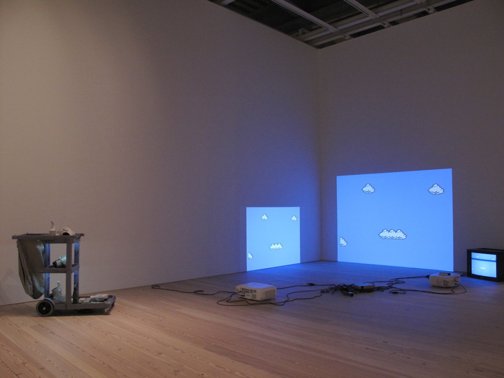 Josh Kline (left), Cost of Living (Aleyda), Plaster, ink, and cyanoacrylate: janitor cart: and LEDs, 2014, Cory Arcangel (right), Super Mario Clouds, Handmade hacked Super Mario Brothers cartridge and Nintendo NEW video game system Edition no. 2/5, 2002, Whitney Museum of American Art, Photograph by Katy Hamer, 2015